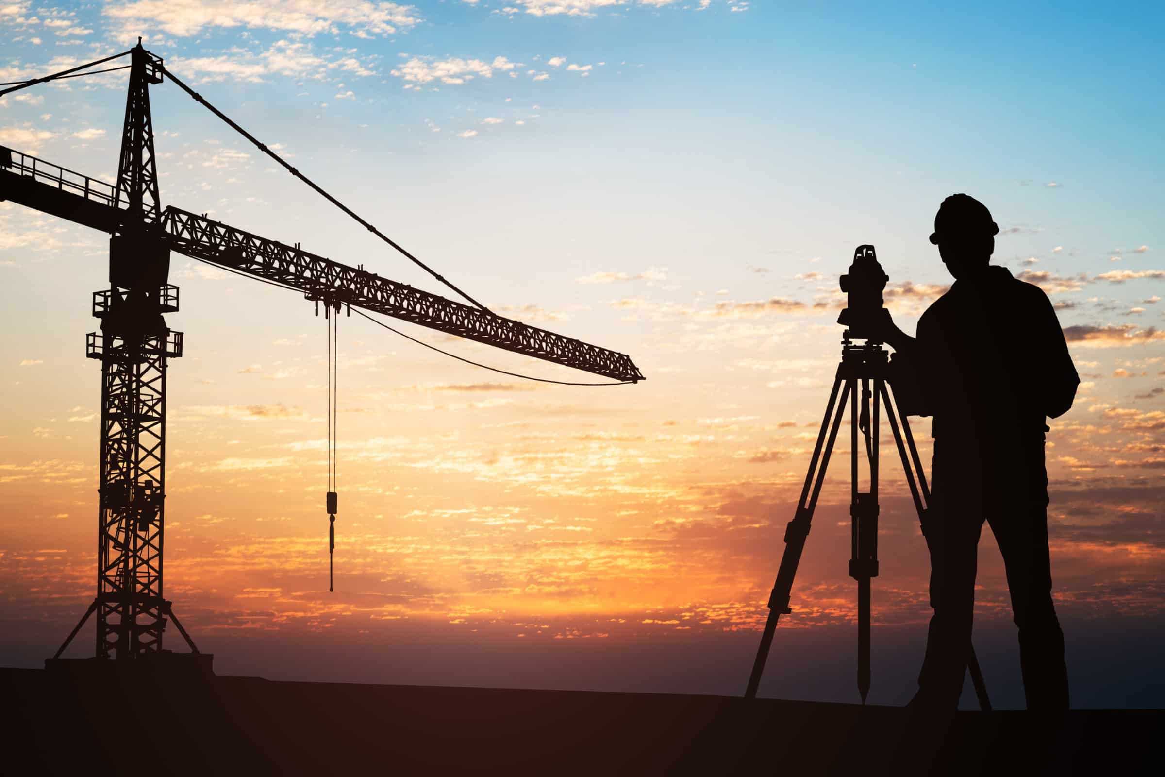 Surveyor Standing With Equipment At Construction Site