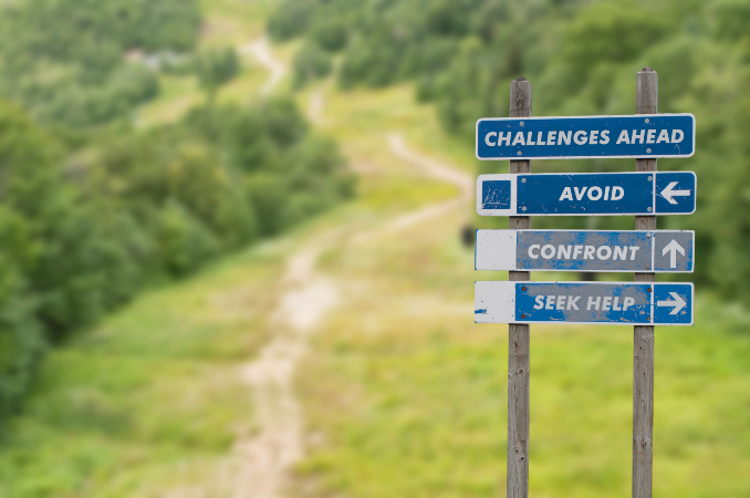 Signpost on top of the mountain warning challenges ahead and three options